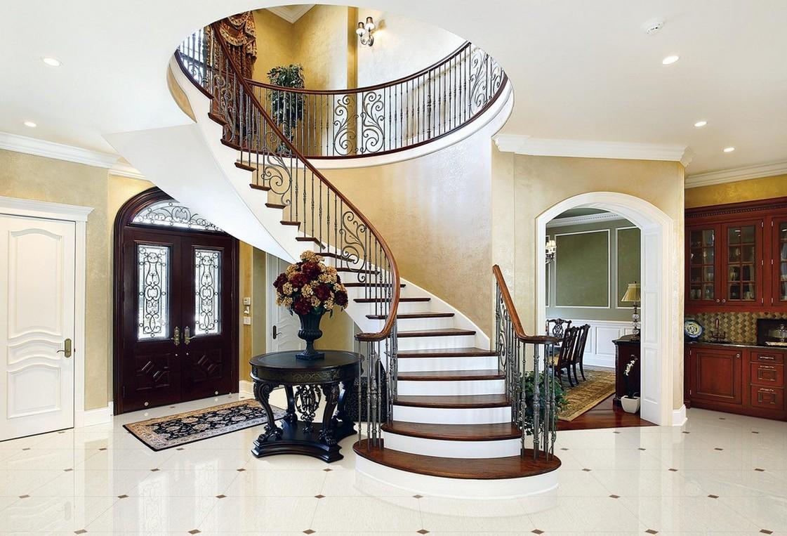 В холл, сделанный в классическом стиле, отлично впишется полукруглая лестница с кованными перилами 